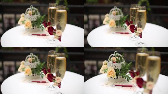 优雅的婚礼餐桌设置香槟长笛，装饰鸟笼插花，书法笔，邀请卡。婚礼浪漫庆典装饰。节日优雅的招待会。