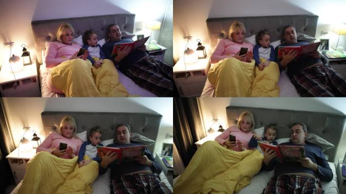女人用手机定闹钟，而她的丈夫和儿子在床上看书