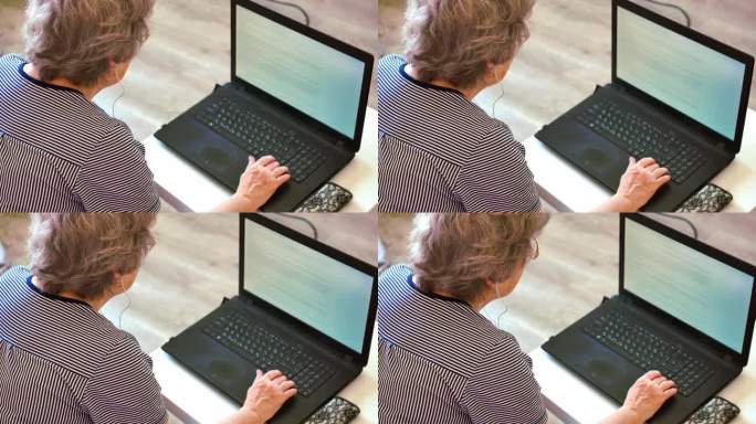 老年妇女戴眼镜看笔记本电脑屏幕，技术日常生活老年妇女从事笔记本电脑，笔记本电脑的作用弥合数字鸿沟，老