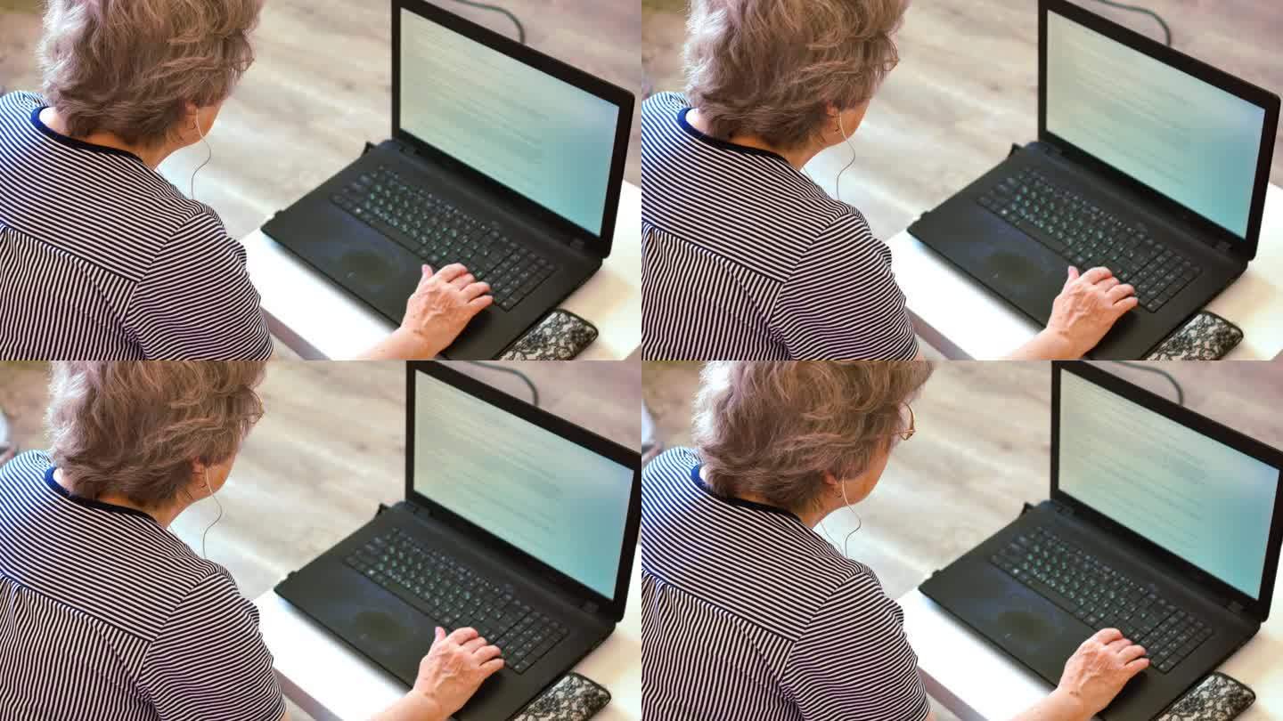 老年妇女戴眼镜看笔记本电脑屏幕，技术日常生活老年妇女从事笔记本电脑，笔记本电脑的作用弥合数字鸿沟，老