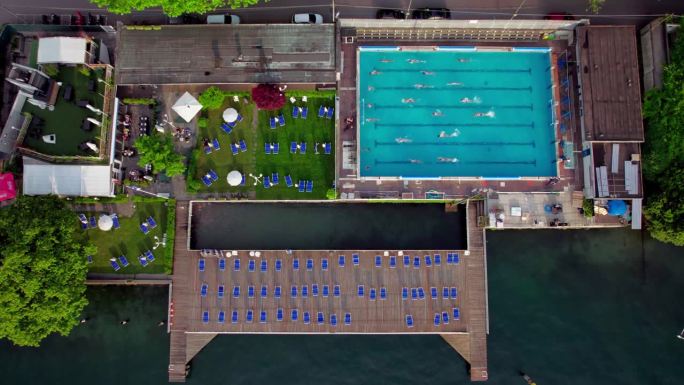 从上到下，人们在科莫湖有餐厅和码头的游泳池里游泳