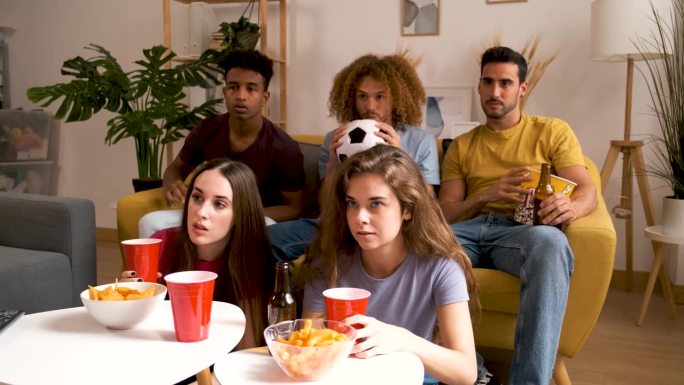 一群心灰意冷的体育迷在电视上看着自己的足球队输球。