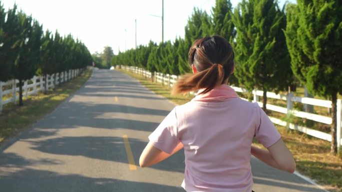 年轻的健身女跑步运动员在热带公园跑步