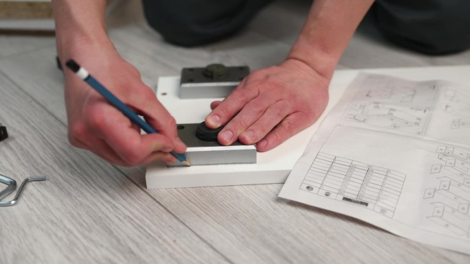 家具组装。工人用铅笔做记号，以便安装家具腿。建筑的概念