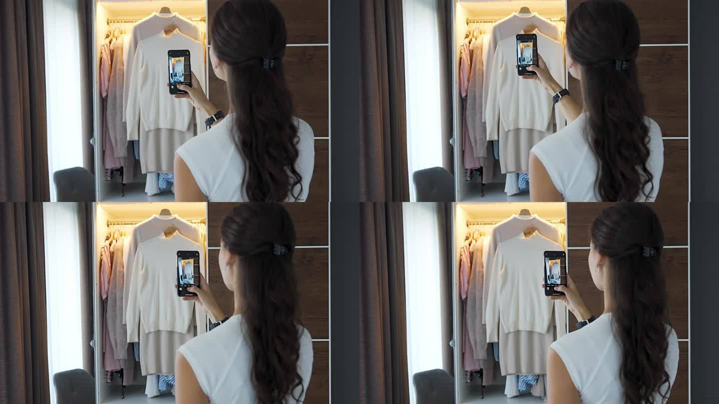 年轻女子在智能手机应用程序中拍摄旧衣服的照片