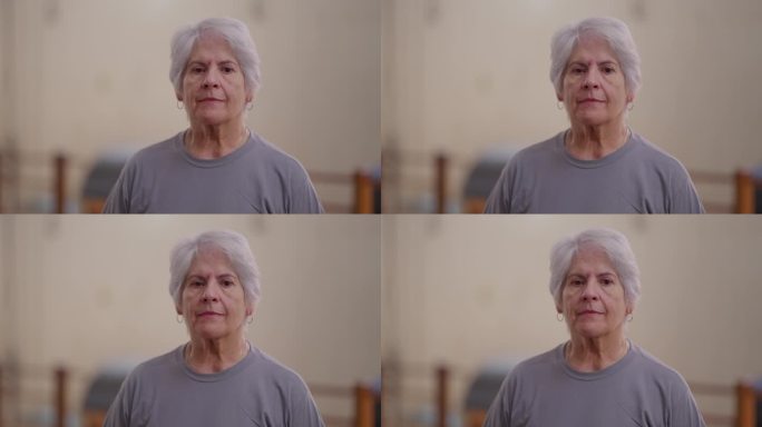 老妇人的特写脸带着中性的表情看着镜头。白发苍苍的白人老年女性