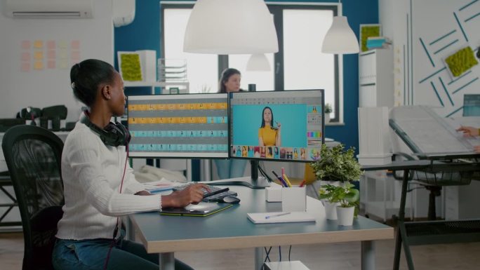黑人女修图师在电脑上用两个显示器分析图像