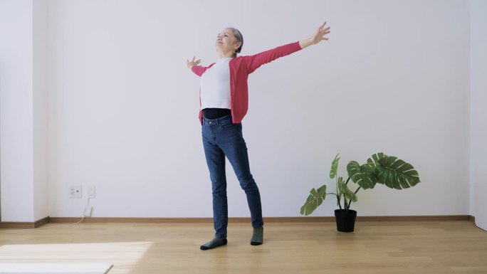 老年妇女在室内做轻度伸展运动