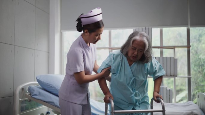 年轻的护士在医院用助行器照顾一位老年妇女。