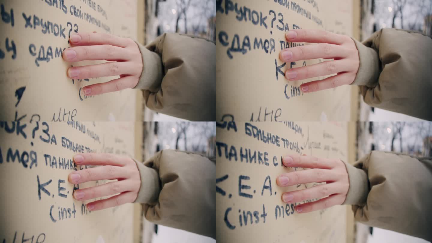 没有修指甲的女性的手在涂成黄色的墙壁上触摸和移动