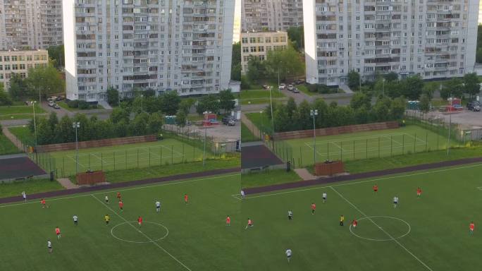 飞过绿色的足球场。在城市公园举行的足球赛。垂直视频