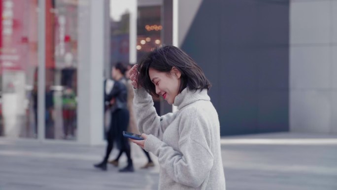 美女逛街看手机微笑开心都市白领生活