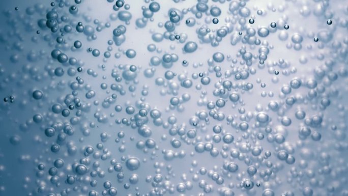 蓝色水中的许多水泡近距离观察，用气泡慢动作抽象水波。