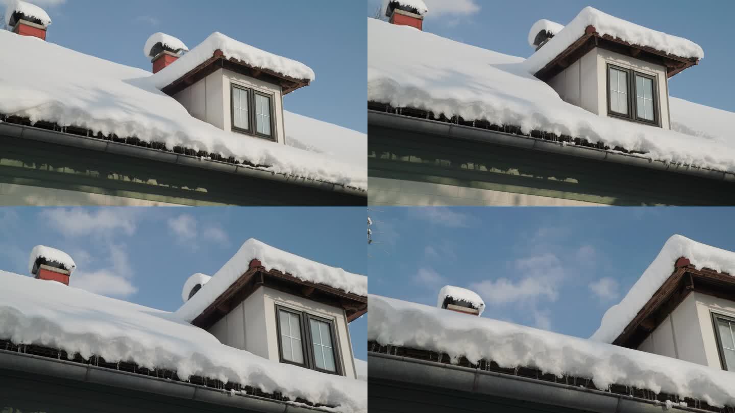 阴沟里的冰柱和带天窗的被雪覆盖的屋顶