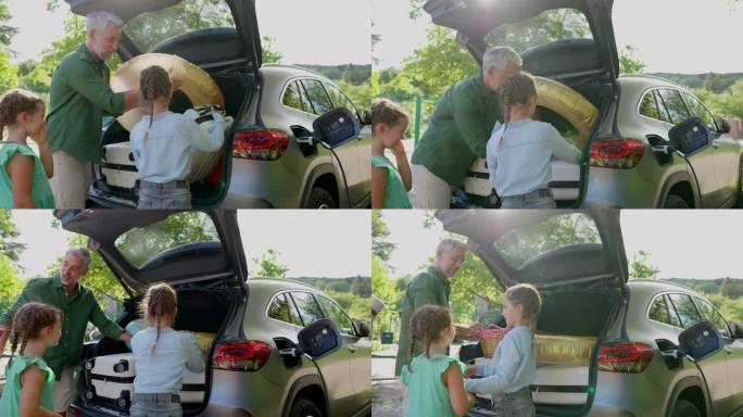 一边给电池充电，一边带着孩子把行李箱装进电动汽车后备箱。