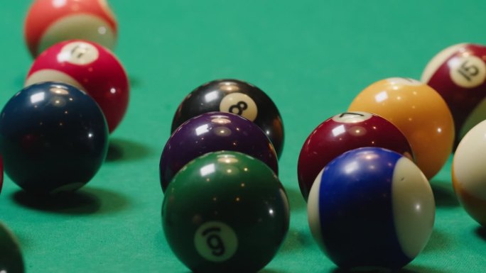 绿色台球桌上的彩色球上有数字特写，准备开始比赛。美式台球、台球、斯诺克。台球团体运动