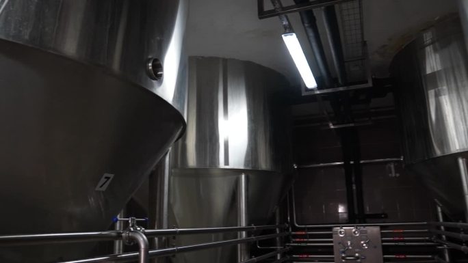 精酿啤酒工厂。用烟斗装啤酒，用桶装啤酒的大容器。过滤在管道中过滤啤酒的过程