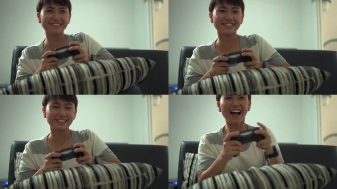 亚洲年轻女孩拿着摇杆在家里的沙发上玩电子游戏。