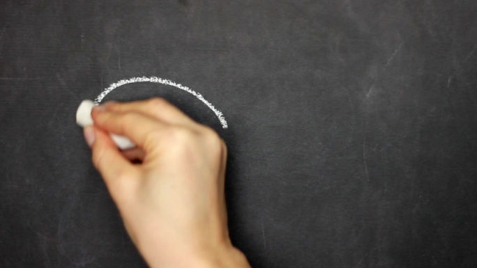 ∞符号。女性的手在黑板上用粉笔写字。