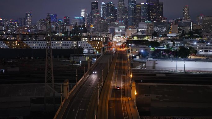 夜间，无人机在第一街大桥上向洛杉矶市中心飞行