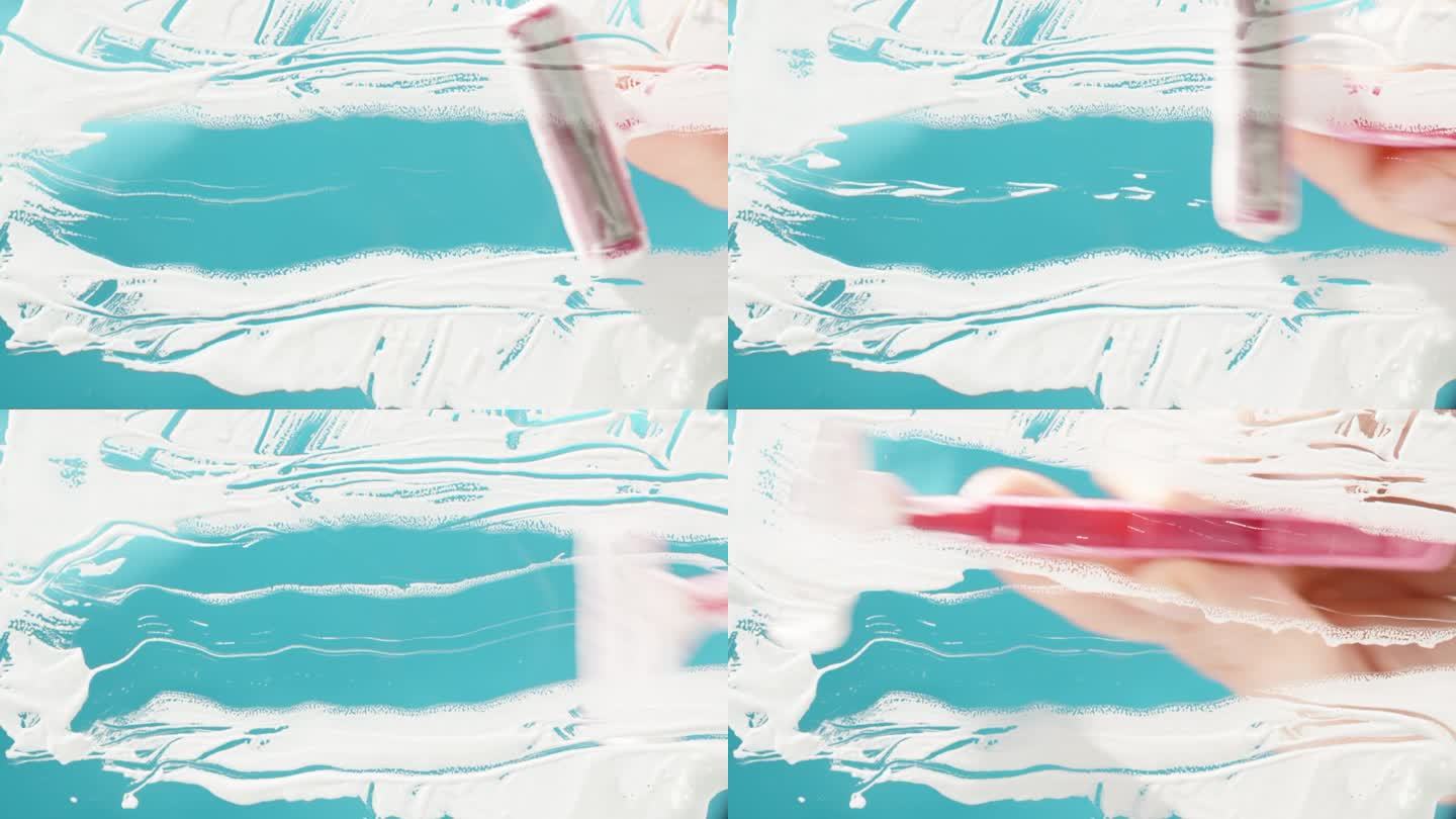 从下面的观点剃须过程与粉红色的剃须刀在蓝色的背景。白色泡沫覆盖了整个框架。