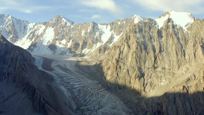 从阿克赛冰川的高处俯瞰。风景如画的山景。吉尔吉斯斯坦美丽的雪山、山脊、丘陵和岩石。