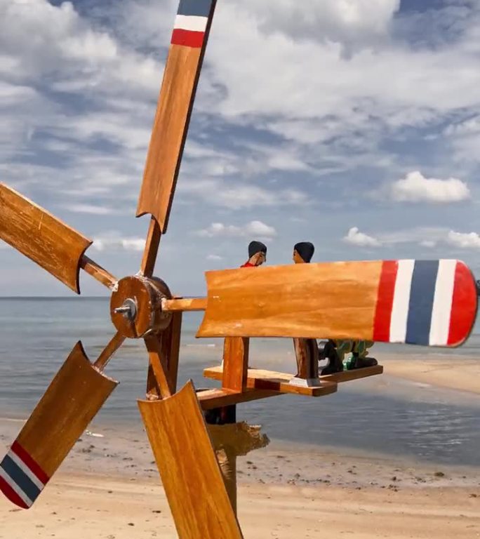 木制的螺旋桨轴驱动着这些小人，测量着海滩上风的方向和强度