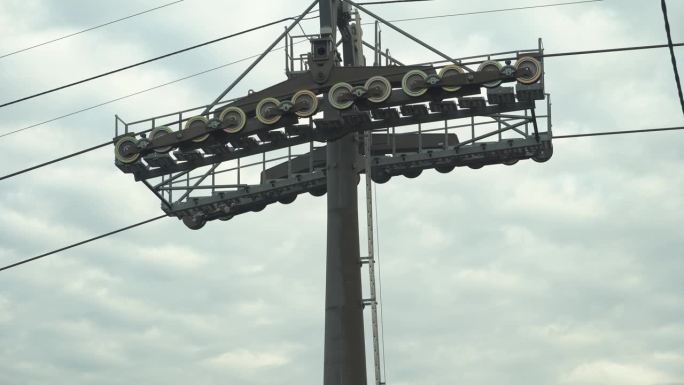 用旋转滚轮支撑滑雪缆车。缆车经过支撑塔。缆车支撑塔有缆车机构和齿轮