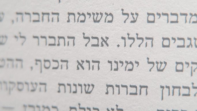 一个宏观平滑和详细倾斜拍摄的希伯来书，白纸上的黑字，4K视频