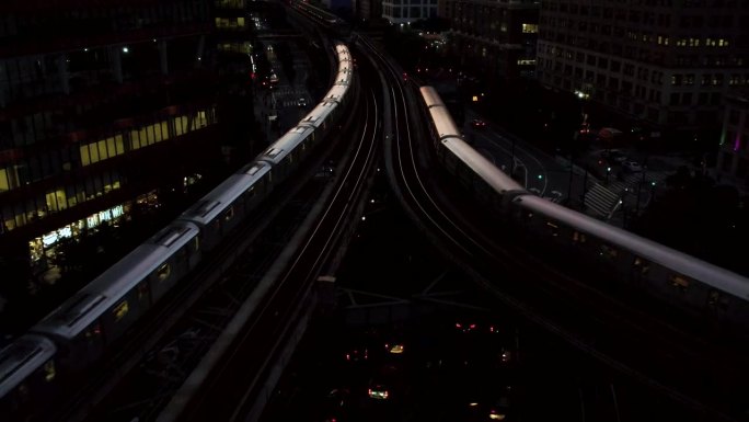 纽约皇后区长岛市夜间，火车在摩天大楼之间的高架地铁线上行驶的4k视频片段
