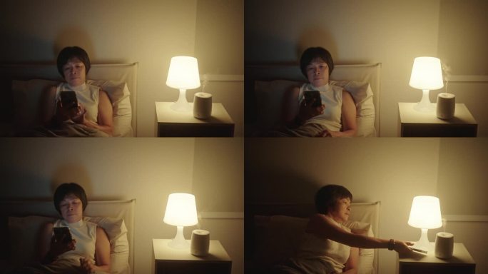 成熟的女人关掉智能手机和灯睡觉。