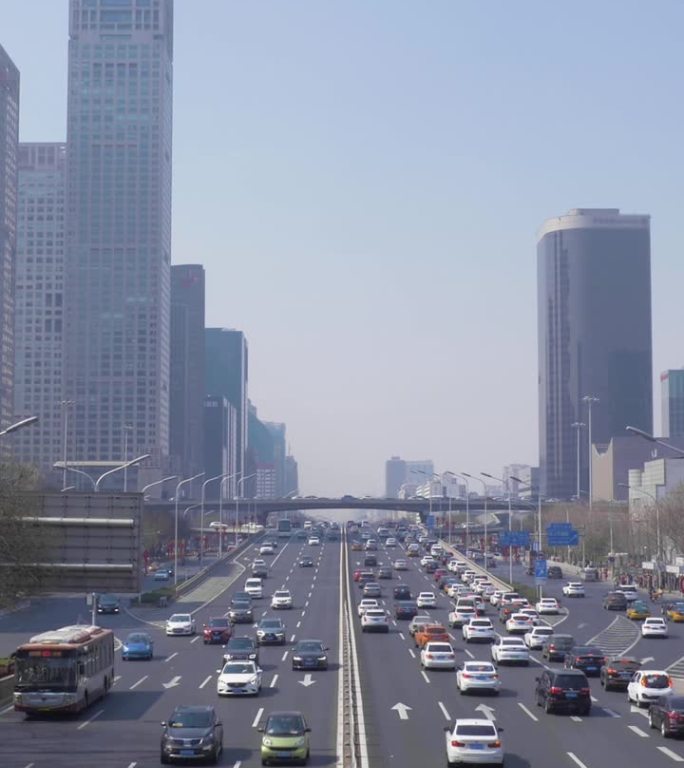 晴朗的一天，中国北京中央商务区。摩天大楼和道路上的汽车交通。垂直视频