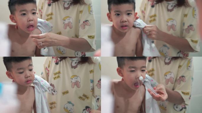 一个男孩正在用生理盐水给孩子洗鼻子。