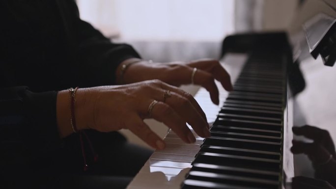 女钢琴家弹奏钢琴时手指放在琴键上的特写侧视图