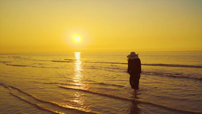 女生一个人在海边慢步逆光人物剪影温馨清晰