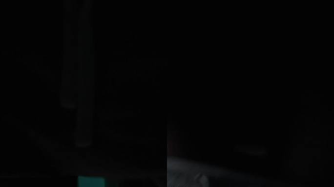 垂直视频。晚上，在昏暗的蓝光下，一个男人坐在马桶上，开始浏览他的手机上的东西，滚动。利用白屏幕的复制