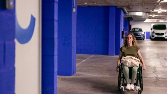 坐轮椅的女人从停车场出来。