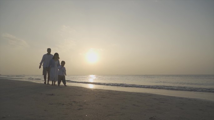 幸福三口之家沙滩齐步走陪伴孩子人物剪影