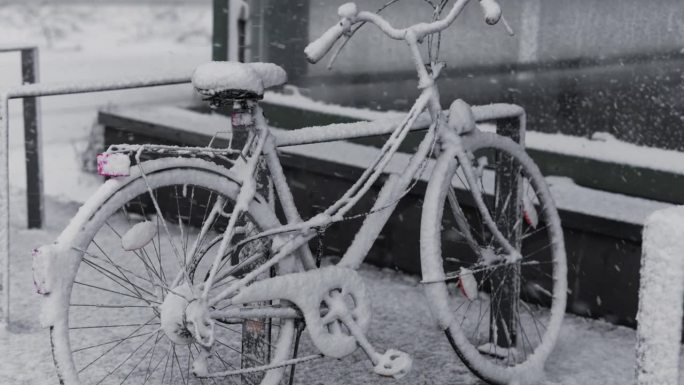 一辆停放的自行车在大雪中被雪覆盖。大城市里冬天的气氛。