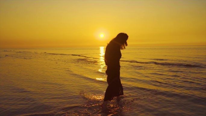 唯美女生海边剪影逆光人物背影沙滩慢步夕阳