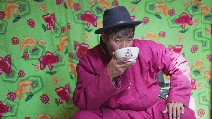 蒙古包里喝传统奶茶的蒙古人