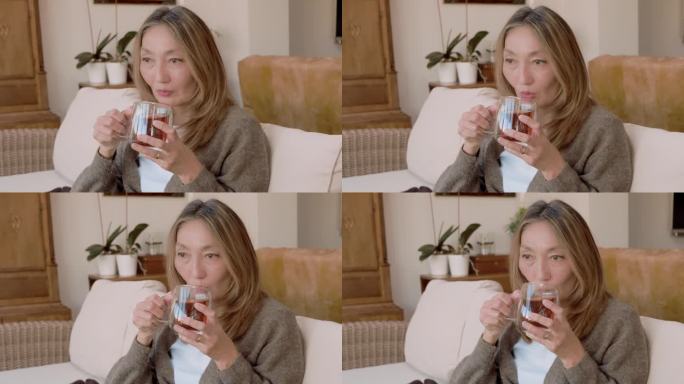 亚洲女性在家里喝咖啡，热巧克力，喝茶，听音乐，和家人交流。生活方式的概念