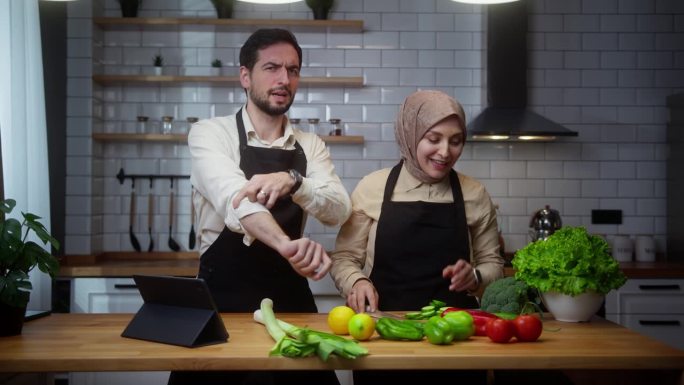 视频博主年轻夫妇厨师在围裙录制视频烹饪课关于素食餐或沙拉在家里的现代厨房