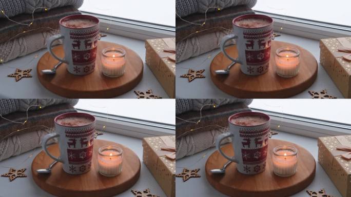 冬天窗台上的静物。红色陶瓷杯热咖啡放在窗台上。圣诞装饰的背景。温馨的家庭照片。采购产品温暖的羊毛针织