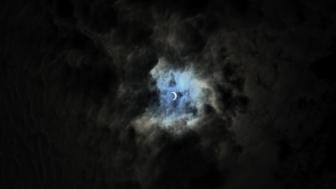 2023年，犹他州的一个夏日，在黑暗多云的天空后面，手持拍摄的几乎是日全食的广角照片