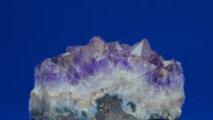 紫水晶石英晶体紫矿物德鲁兹旋转近距离拍摄蓝色背景闪耀工作室照明