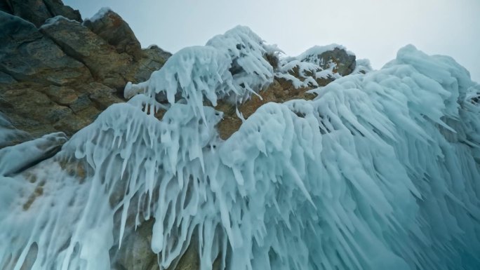 岩石上悬挂着锋利的冰刺。冰柱在我头上。贝加尔湖，西伯利亚，俄罗斯。