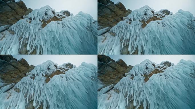 岩石上悬挂着锋利的冰刺。冰柱在我头上。贝加尔湖，西伯利亚，俄罗斯。