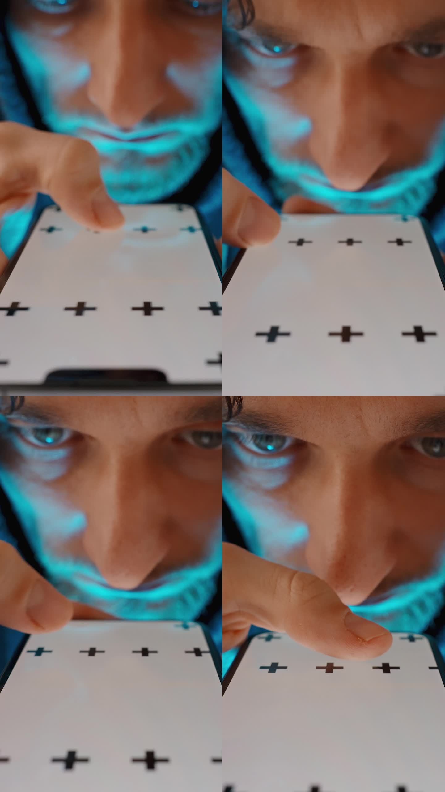 垂直视频。智能手机屏幕上的蓝光照亮了这个穿着卫衣的年轻人的脸，他正在用手指滑动页面。色度键模型。
