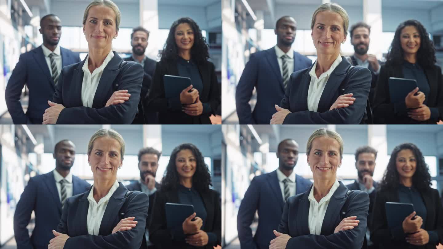 一群快乐的多民族团队，男女经理、专家和商务人士在镜头前摆姿势微笑。一个站在第一位的自信女性团队领导的